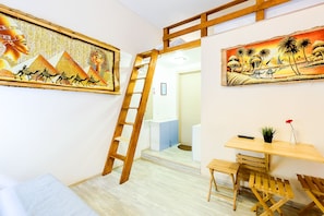 Experience ancient Egyptian culture in this unique room, featuring a loft area, desk, and artwork depicting pyramids and desert landscapes.