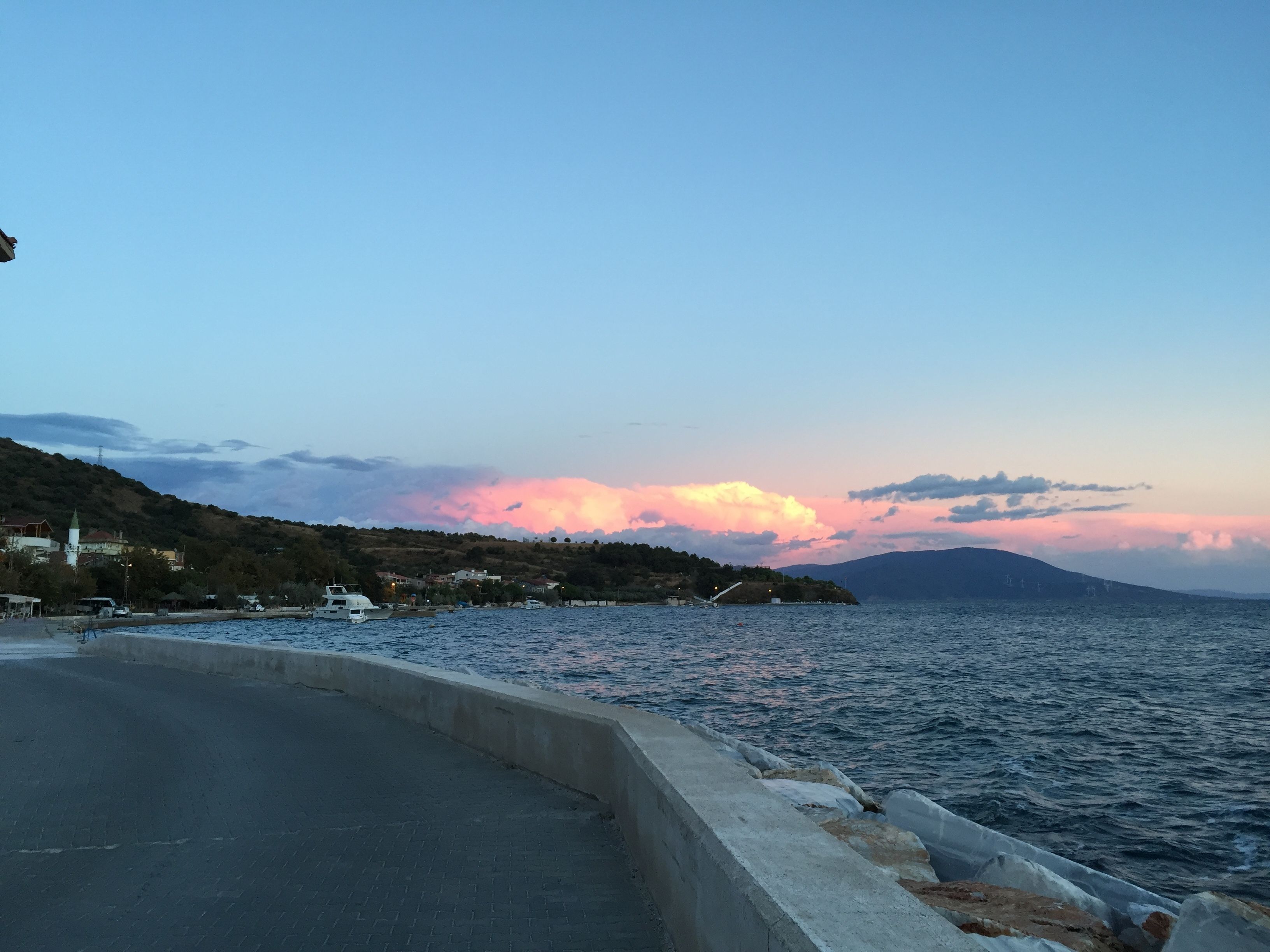 A coastal road with a view of the sea and a sunset.