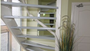 A staircase with white railings and a door with a latch. - Pension Villa Tanahlot (Zandvoort)