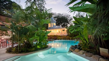 Een buitenzwembad, ligstoelen bij het zwembad