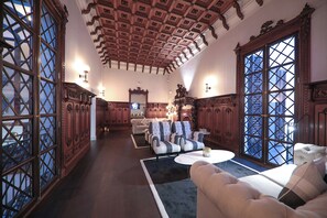 A spacious living room with a high ceiling, large windows, and classic wooden furniture. - Summum Boutique Hotel, member of Meliá Collection (Palma de Mallorca)