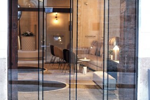 A modern interior with a glass door, a seating area with chairs and a table, and a visible sign reading "SÜMMUM". - Summum Boutique Hotel, member of Meliá Collection (Palma de Mallorca)
