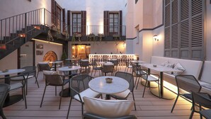Un patio con asientos al aire libre, una escalera y una zona de bar.