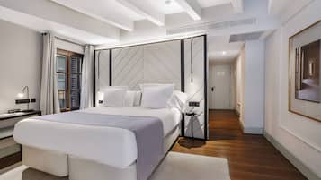 Una habitación de hotel moderna con una cama grande, un vestidor y vista al pasillo.