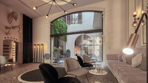 Un interior moderno con una pared de vidrio curva, zona de estar y un jardín exterior visible.