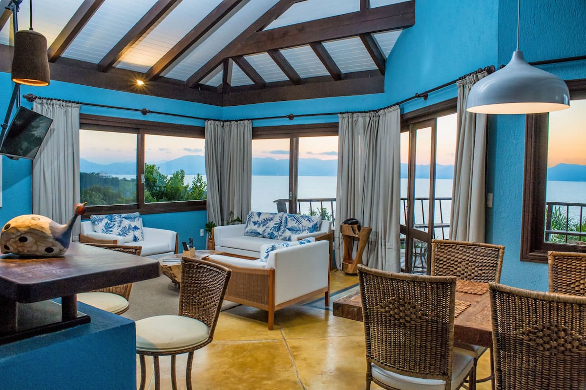 Una habitación con vistas al lago, amoblada con un sofá, sillas y una mesa.