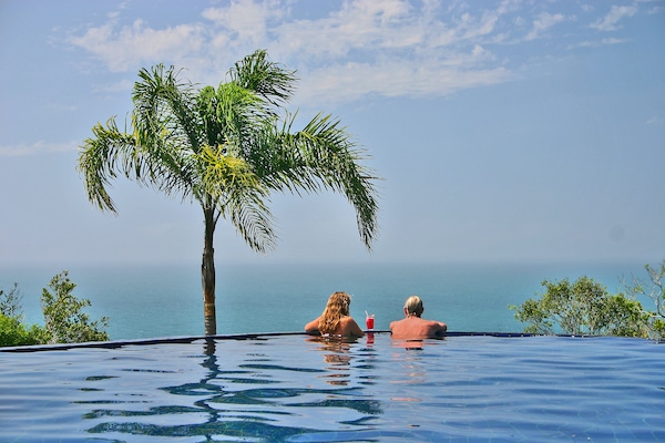 Una piscina al aire libre, sillones reclinables de piscina