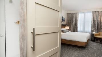Een hotelkamer met een bed, een stoel, een bureau en een douche.