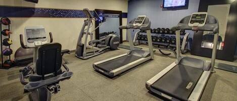 A gym with treadmills, elliptical machines, and weight machines.