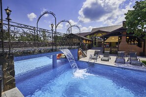 Una piscina techada, una piscina al aire libre de temporada, sombrillas