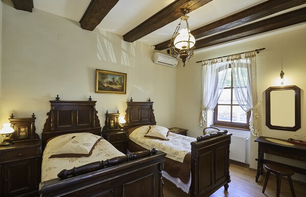 A traditional bedroom with two wooden beds, a desk, and a window with curtains. - Resort Ambient (Cristian)