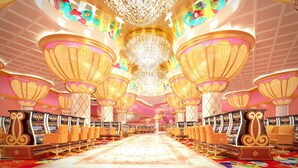 A spacious hotel lobby with ornate chandeliers, rows of seating, and a central decorative column. - Okada Manila (Parañaque)