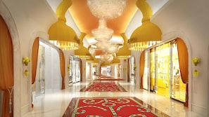 A luxurious hotel corridor with a red carpet, chandeliers, and ornate golden arches. - Okada Manila (Parañaque)