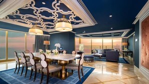 A luxurious dining area with a round table, chairs, and a chandelier. - Okada Manila (Parañaque)