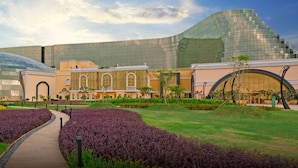 A modern building with a dome structure, a pathway, and landscaped gardens. - Okada Manila (Parañaque)