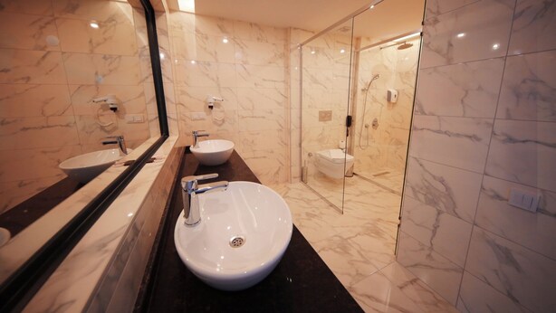 A modern bathroom with two sinks, a glass shower enclosure, and marble flooring. - Sey Beach Hotel & Spa (Alanya)