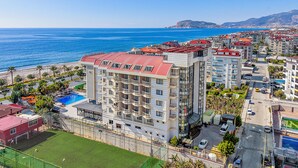 A coastal hotel with multiple floors, balconies, and a swimming pool. - Sey Beach Hotel & Spa (Alanya)