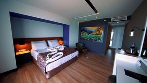 A hotel room with a large bed, a desk, a chair, and a painting on the wall. - Sey Beach Hotel & Spa (Alanya)