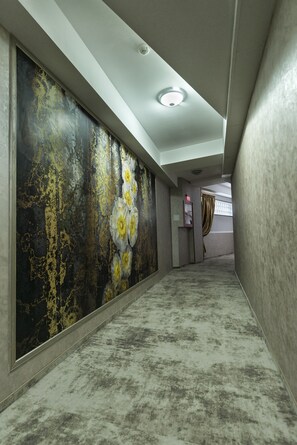 Un pasillo con pared texturizada y un gran mural floral.