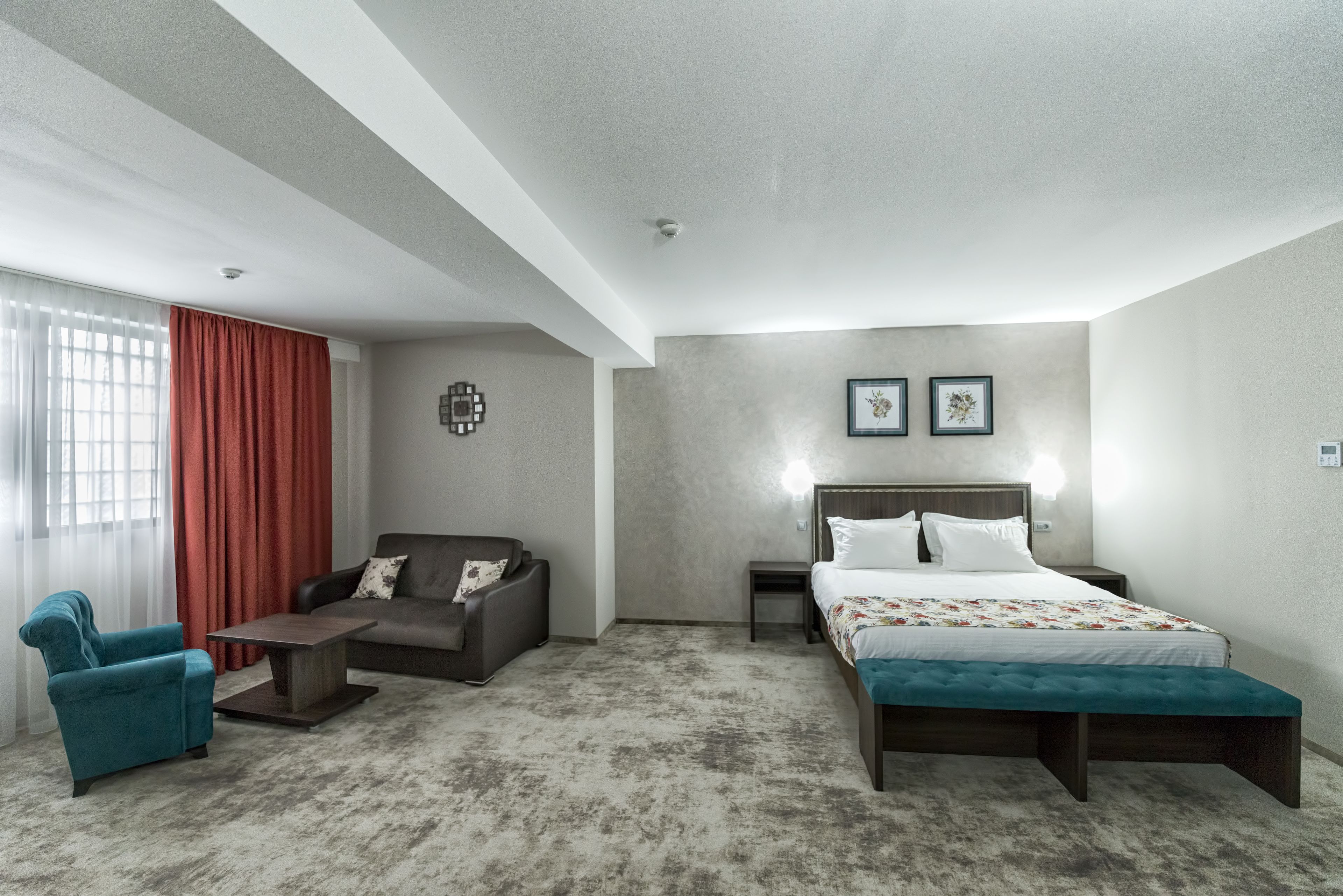 Un dormitorio moderno con una cama grande, un sofá, una mesita de centro y una silla.