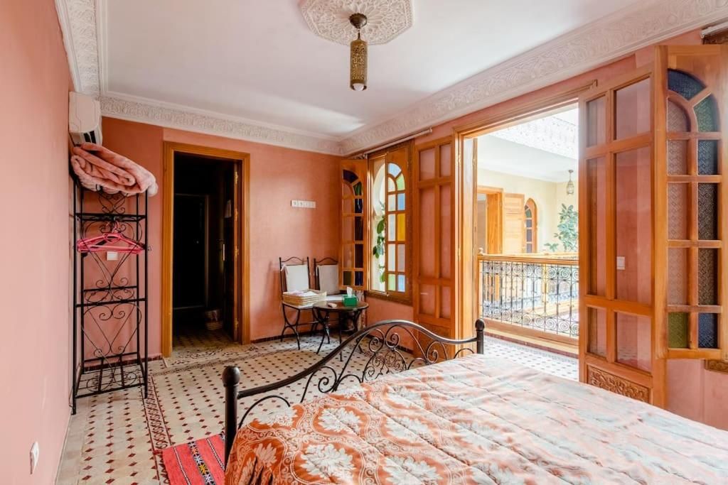 Un dormitorio con cama, escritorio y balcón.