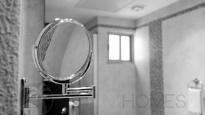 A bathroom with a round mirror, a window, and a towel rack. - Turquesa Penthouse 2 BDRM sleeps 5 (Tulum)