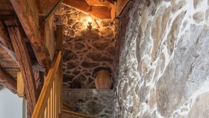 A wooden staircase with a stone wall on one side.