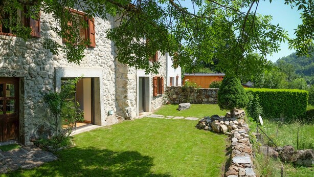 A stone building with a stone pathway leading to a wooden door.