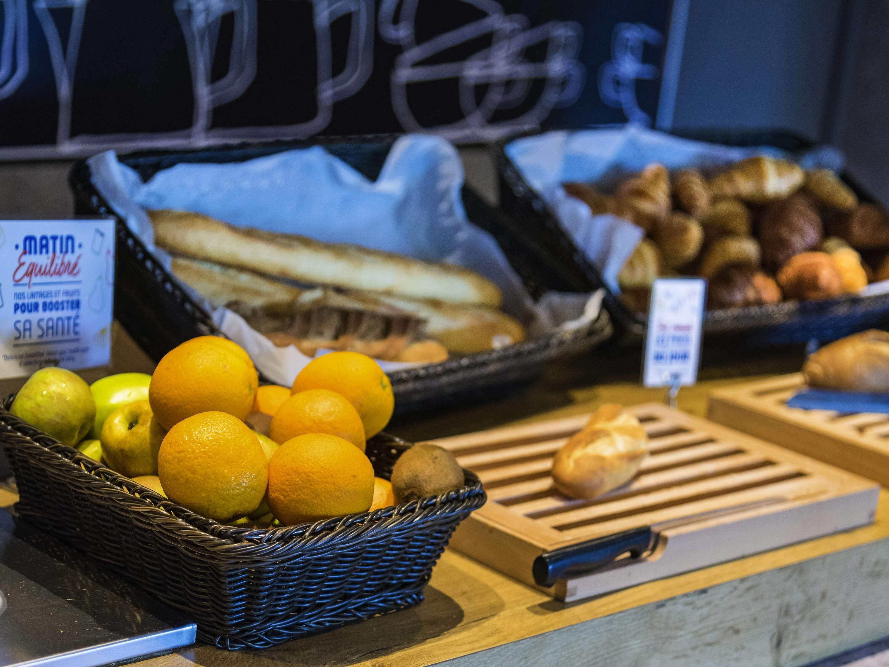 A display of fruits and pastries in a bakery setting.