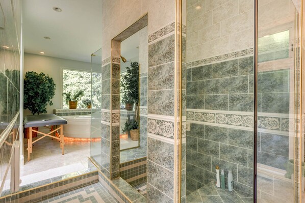 A modern bathroom with a glass shower enclosure, marble tiles, and a bench. - Exclusive House On Foothill with hot tub, sauna and jacuzzi. (Welches)
