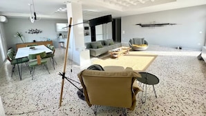 A modern living space with a dining area, a sofa, and a coffee table.