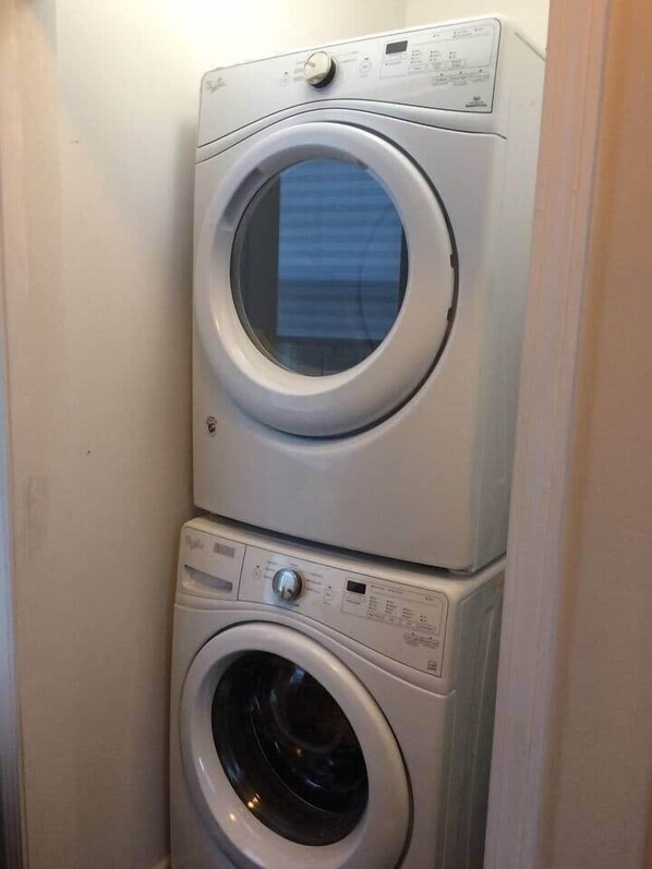A stacked washer and dryer unit in a laundry room.