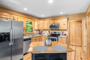 A modern kitchen with wooden cabinets, stainless steel appliances, and a granite countertop.