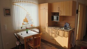 A compact kitchen with wooden cabinets, a microwave, and a sink.