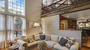 A spacious living room with a high ceiling and a view of the outdoors through large windows. - Ranked #1 by VRBO in Flagstaff for 4 years! AC, Pets and Hot Tub! (Flagstaff)