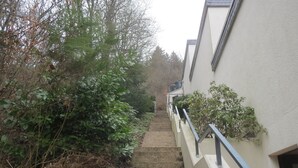 A narrow staircase leading up to a building with a white exterior and a metal railing. - *** Star apartment, large terrace on the south slope with panoramic views near the Rursee  (Simmerath)
