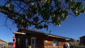A rustic cabin with a deck, outdoor seating, and a fire pit. - Wilderness Spirit Cabins 'Bear Cave' cabin-family friendly/sportsman paradise (Corvallis)