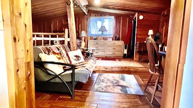 A wooden interior with a bed, dresser, and a window with curtains. - Wilderness Spirit Cabins 'Bear Cave' cabin-family friendly/sportsman paradise (Corvallis)