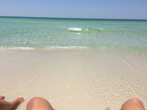 Ein Strand mit klarem türkisblauem Wasser und einem Sandufer.