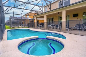 A swimming pool with a sunken area, surrounded by lounge chairs and a covered patio area.