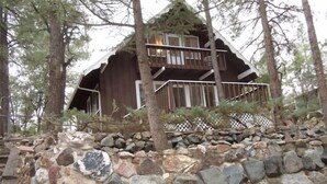 A rustic cabin with a wooden exterior, a balcony, and a stone foundation. - Charming Chalet - Walk to Whiskey Row! Dog friendly (Prescott)