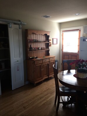 A kitchen with wooden cabinets, a dining table, and a refrigerator.