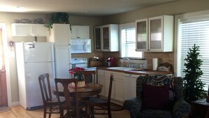 A compact living space with a dining area, kitchenette, and a cozy seating area.