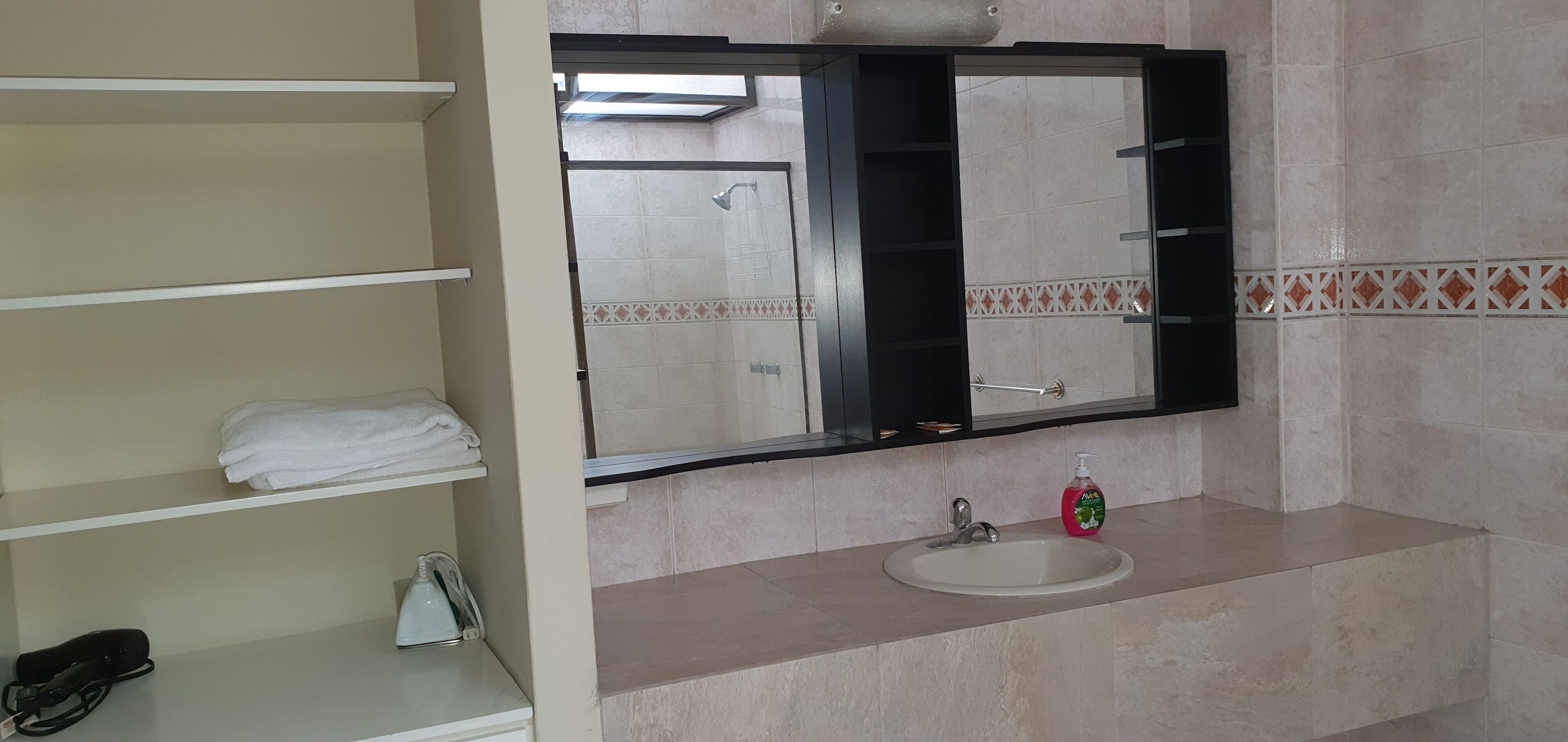 A bathroom with a sink, a mirror, and a towel rack.