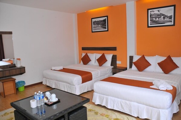 A hotel room with two beds, a small table with toiletries, and a picture on the wall.