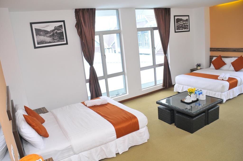 Ein Hotelzimmer mit zwei Betten, einem Couchtisch und großen Fenstern.