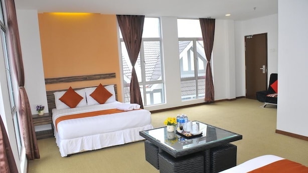 Una habitación de hotel con una cama, una mesa de centro de vidrio y vistas al exterior.