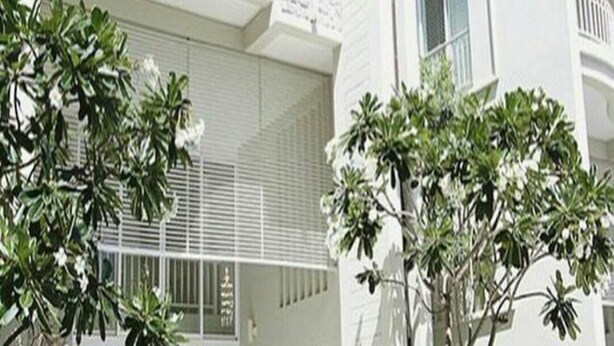 A modern multi-story building with balconies and a stone accent wall. - Baan Sea Talay (Cha-am)