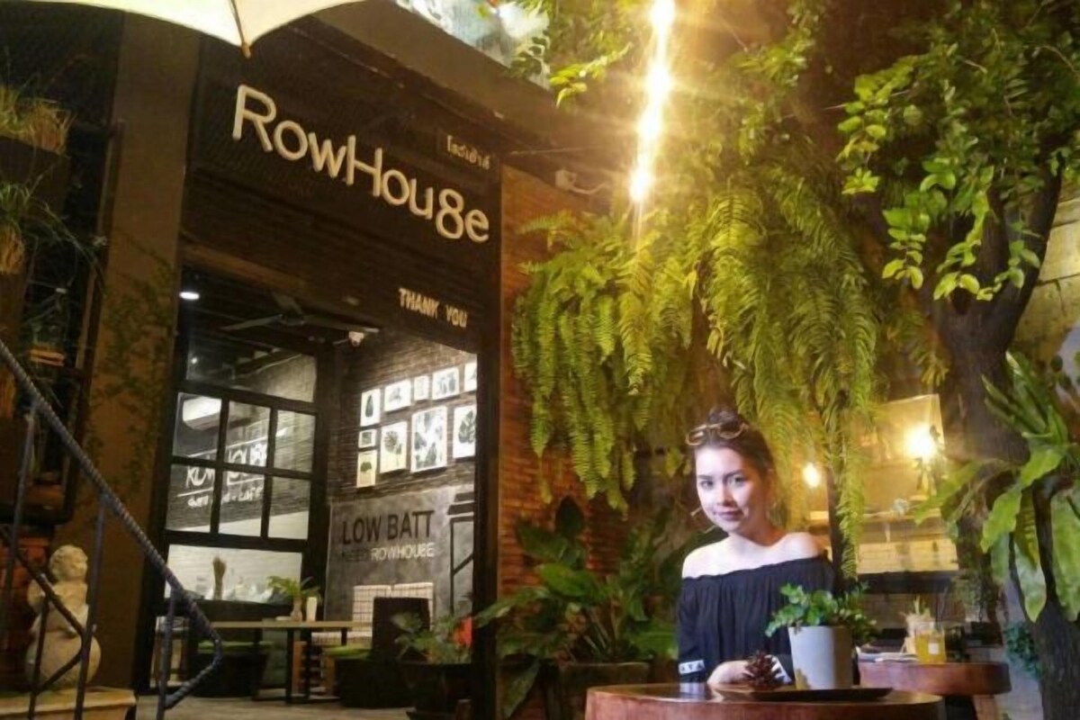 A restaurant named 'RowHouse' with a brick facade and indoor plants.