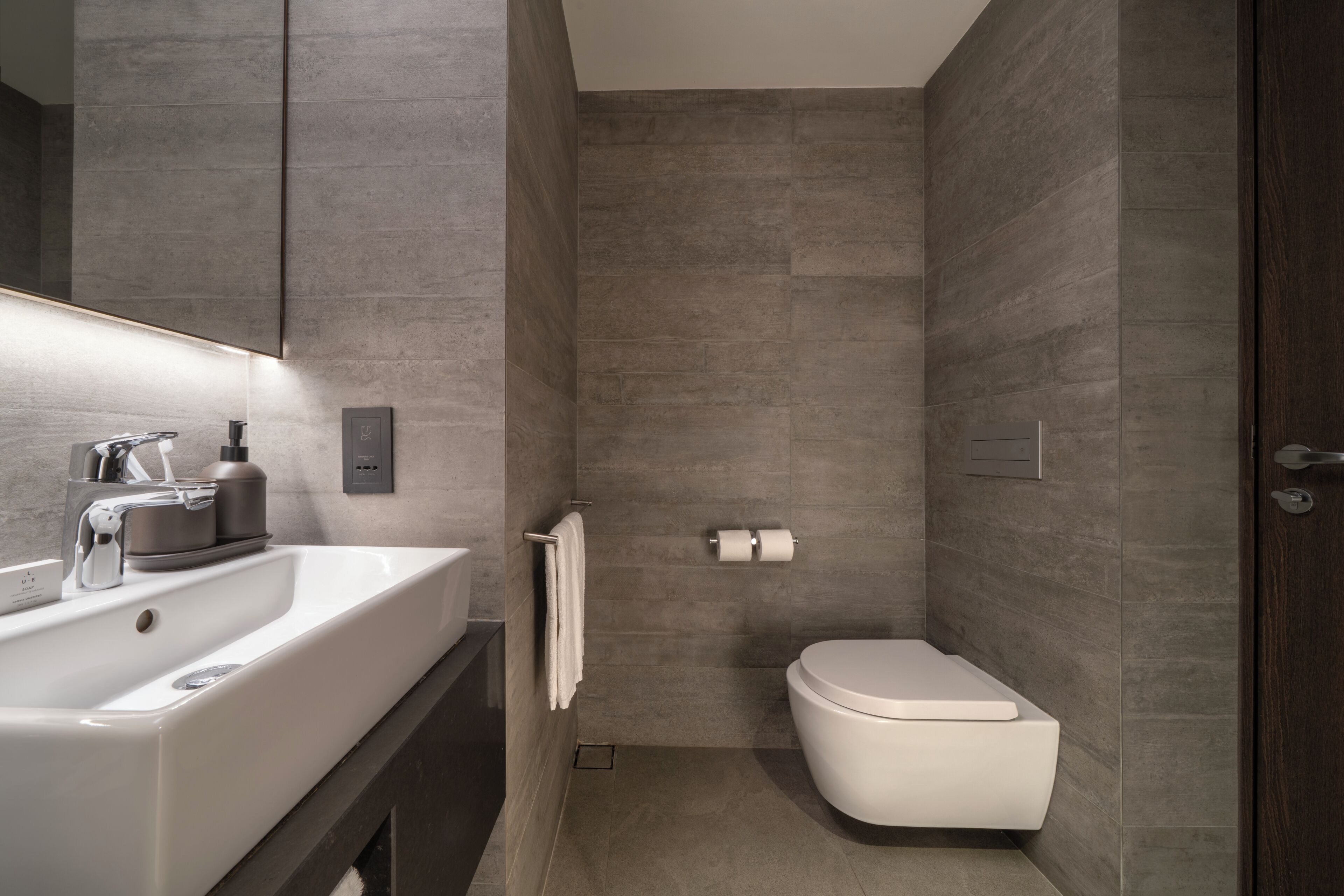 Un baño moderno con un lavamanos grande, inodoro y zona de ducha.